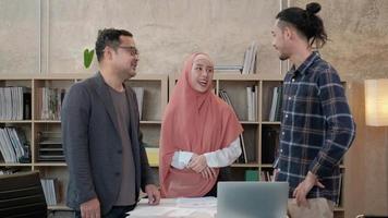 equipe de colegas de jovens startups que são islâmicos conversam com seu chefe sobre projetos financeiros trabalhando em uma empresa de comércio eletrônico. use o laptop para comunicação online via internet em um pequeno escritório. video