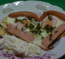 Heart shaped sausage dish with chicken eggs photo