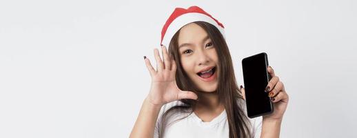 Mujer asiática con smartphone en mano que posa como selfie o videollamada foto