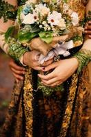 Wedding bouquet of flowers in brides' hands photo