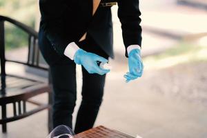 The hands of a man wearing blue gloves preparing for an event
