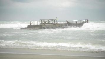 Italiens kust Tyrrenska havet i stormigt väder - vågor faller på den gamla träpiren video
