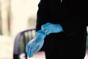 The hands of a man wearing blue gloves preparing for an event photo