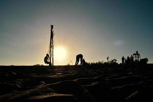 Silhouettes of people playing on the beach in the morning photo