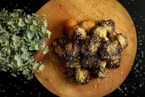 Delicious little chocolate cake sprinkled with crispy waffle slices on dark background photo