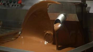 Geschmolzene Schokolade wird in einen Bottich gegossen - eine Pralinenwerkstatt