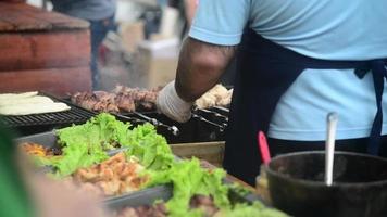 nourriture de rue - le cuisinier prépare la viande sur le gril - fumée, charbon de bois, barbecue