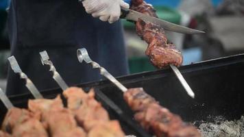 straatvoedsel - kok bereidt vlees op de grill - rook, houtskool, barbecue video