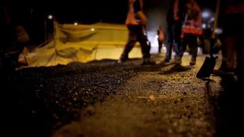 Los trabajadores de la industria de reparación de carreteras colocando asfalto de piedra durante las obras de reparación de la calle transporte de tráfico de construcción