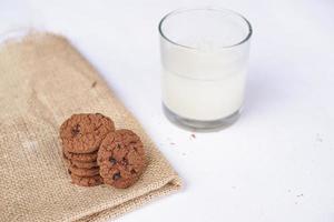 Chocolate cookies on a white table with milk photo