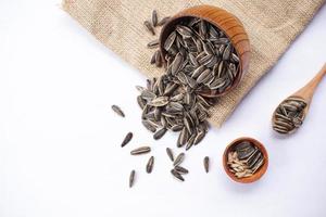 Sunflower seeds in a wooden bowl on a white table photo