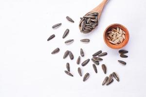 Sunflower seeds in a wooden bowl on a white table photo