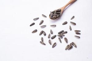 Sunflower seeds in a wooden bowl on a white table photo