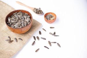 Sunflower seeds in a wooden bowl on a white table photo