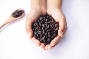 coffee beans in hand on white table photo