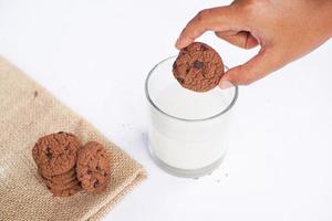 galletas de chocolate en una mesa blanca con leche foto