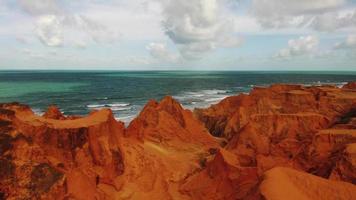 Aerial view of the red desert and the ocean in the background video