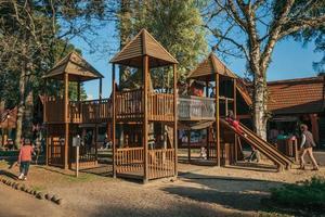 nova petropolis, brasil - 20 de julio de 2019. parque infantil entre árboles con niños jugando al atardecer en el parque de la aldea de inmigrantes de nova petropolis. un pueblo rural fundado por inmigrantes alemanes. foto