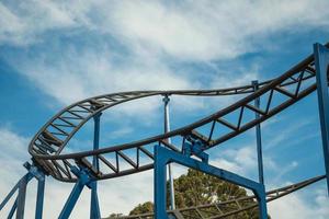 canela, brasil - 21 de julio de 2019. rieles de acero y vigas de una montaña rusa bajo un cielo azul con nubes en el parque de atracciones alpen cerca de canela. un pequeño pueblo encantador muy popular por su ecoturismo. foto