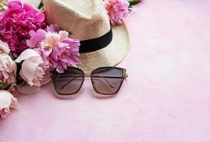 peonías rosas y sombrero sobre un fondo de hormigón rosa foto