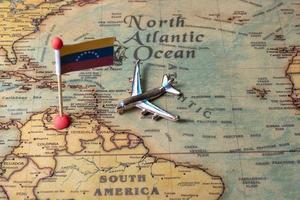 The flag of Venezuela and the plane on the world map. photo