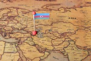 Azerbaijan is marked with a flag on the map. Flag of Azerbaijan on the world map. photo