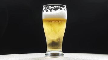 cerveza fría en un vaso con gotas de agua. cerveza artesanal de cerca. como agua de lluvia video