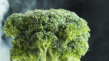 roterende broccoli en rook op zwarte achtergrond video