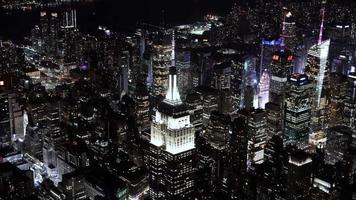 4k-Antennensequenz von New York City, USA - Nahaufnahme des Empire State Buildings bei Nacht von einem Hubschrauber aus gesehen