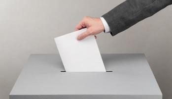 Gray ballot box. Presidential and parliamentary elections. The voter throws the ballot into the ballot box. photo