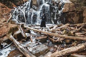 Hombre practicando kendo con espada de bambú sobre fondo de cascada foto