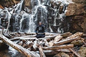 Hombre practicando kendo con espada de bambú sobre fondo de cascada foto