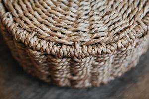 Elemento de una cesta de mimbre redonda sobre un fondo de madera foto