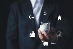 Businessman in suit is holding piggy bank. Finance Savings concept. photo