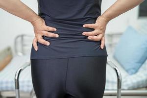 paciente asiática dama dolor de espalda, cintura y lumbar ortopédico con andador. foto