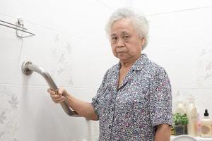 Asian senior or elderly old lady woman patient use toilet bathroom handle security in nursing hospital ward, healthy strong medical concept. photo