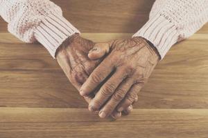 La mano del anciano descansa sobre la mesa. foto