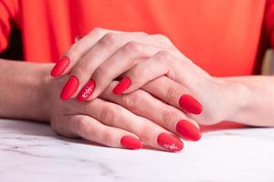 manicura mate roja en manos femeninas para el día de san valentín foto