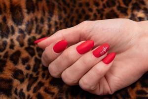 Red matte manicure on female hands for valentines day photo