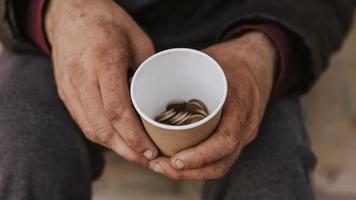 vista frontal, hombre sin hogar, tenencia, taza, con, monedas foto