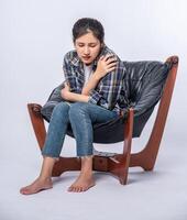 A woman who is uncomfortable and sits on a chair photo