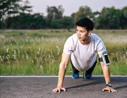 Men wear white shirts with muscles push up on the street. photo