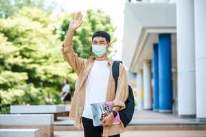 Men wear masks, carry books, and carry a backpack on the stairs. photo