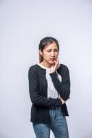 A woman sick with a toothache and a hand holding on the cheek photo