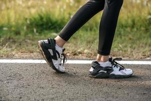 Pies de la mujer del corredor que se ejecutan en primer plano de la carretera en el zapato. concepto de estilo de vida saludable deportivo.