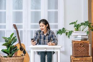 Women sit at the desk and use the phone to coordinate. photo