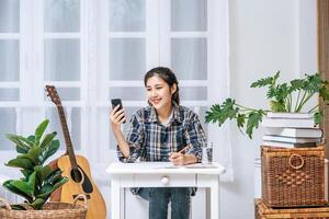 Women sit at the desk and use the phone to coordinate. photo