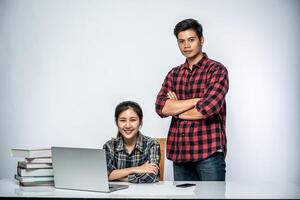 Men teach women how to work with laptops at work. photo