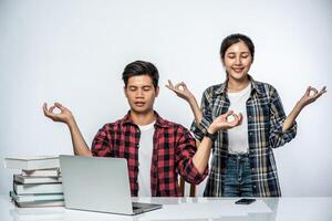 Men and women use laptops in the office and make hand signs ok. photo