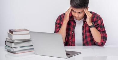 Men use laptops in the office and are stressed. photo